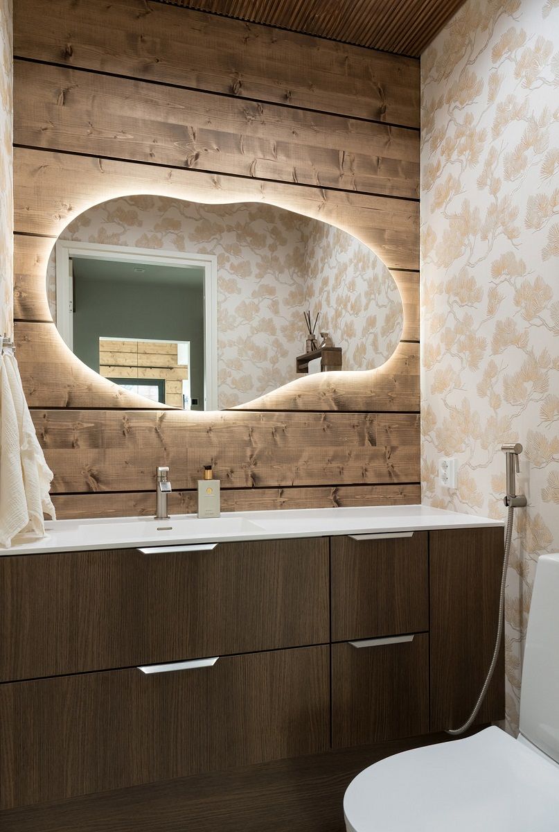 Lo specchio retroilluminato a forma di nuvola completa l'illuminazione della toilette